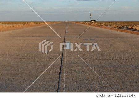 Concrete road stretches across the vast landscape of Karakalpakstan in Uzbekistan Concrete road stretches across the vast landscape of Karakalpakstan in Uzbekistan 122115147