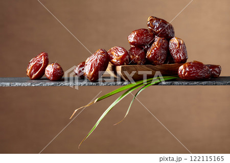 Closeup of sweet dates in wooden dish. Closeup of sweet dates in wooden dish. 122115165