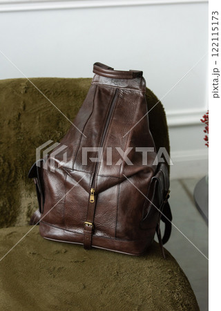 Brown leather backpack on a luxury sofa, close up. 122115173