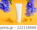 cosmetic moisturizer cream tube, blue flowers and marigolds on yellow background. skincare, body cream, gel, sunblock, sunscreen, shampoo, sun skin protection. blank bottle template mockup 122116666