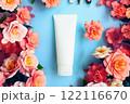 Cosmetic tube, pink roses flowers on blue background. White moisturizing Cream, skincare product blank mockup package. Bottle of moisturizer, sunscreen lotion, balsam, toothpaste, scrub 122116670