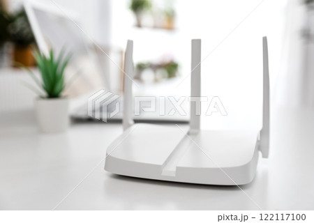 Modern wi-fi router on light table in room Modern wi-fi router on light table in room 122117100