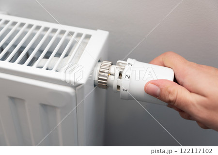 Person is adjusting the temperature on a radiator 122117102