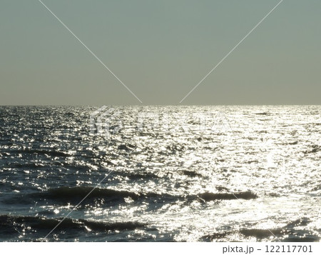 silver sea waves with sun path on surface and smooth horizon against clear sky, seascape without people and ships on sunny cold day, empty sea space background silver sea waves with sun path on surface and smooth horizon against clear sky, seascape without people and ships on sunny cold day, empty sea space background 122117701