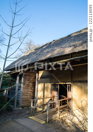 夕暮れの日差しを浴びるかやぶき屋根の古民家の入り口　ロンドン郊外のキューガーデンにて 122118095