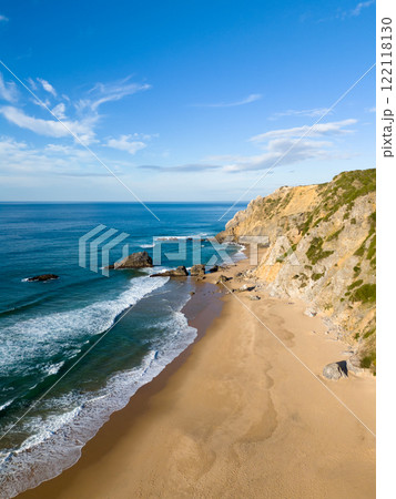 Adraga Beach and Cliffs on Sunny Day. Atlantic Ocean, Portugal. Aerial View Adraga Beach and Cliffs on Sunny Day. Atlantic Ocean, Portugal. Aerial View 122118130