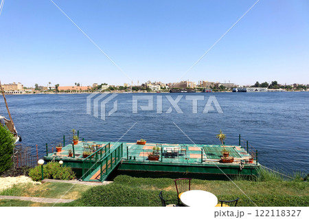 Pier Tourists Explore the Nile River While Crossing in Luxor Egypt on a Clear Sunny Day Pier Tourists Explore the Nile River While Crossing in Luxor Egypt on a Clear Sunny Day 122118327