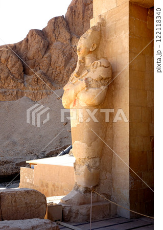 An ancient statue in the temple of Hatshepsut in Egypt surrounded by architectural ruins An ancient statue in the temple of Hatshepsut in Egypt surrounded by architectural ruins 122118340