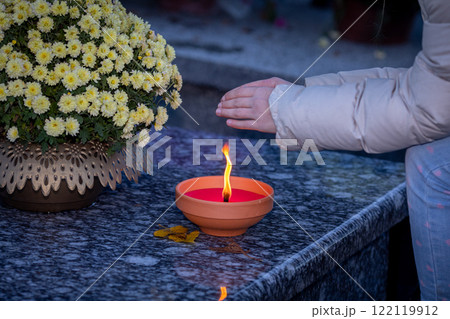 The Candle Lighting Ritual at a Memorial Site creates a serene and comforting atmosphere The Candle Lighting Ritual at a Memorial Site creates a serene and comforting atmosphere 122119912