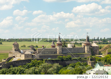 Historic medieval castle with towers under a blue sky and green surroundings 122120132