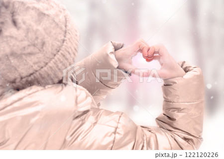 Winter heart gesture with sunshine and snow in a cozy atmosphere. Demonstrating color of 2025 year mocha mousse 122120226