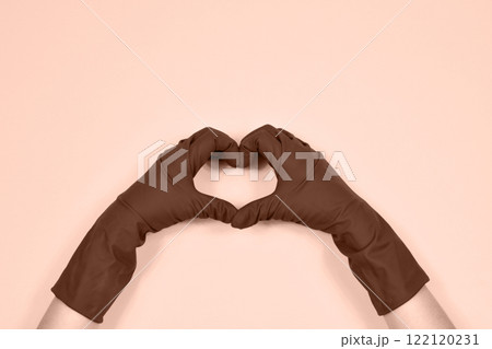Working hands in rubber protective gloves show the heart. Working hands in rubber protective gloves show the heart. 122120231