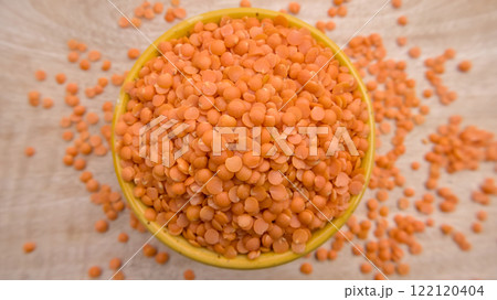 Red Lentils (Masoor Dal) Split and Dehusked in a Yellow Bowl - Rustic Close-Up Top View Flat Lay 122120404