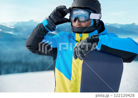 Close up Portrait of snowboarder in Carpathian Mountains, Bukovel Snowboarder. A mountain range reflected in the ski mask. wearing ski glasses Close up Portrait of snowboarder in Carpathian Mountains, Bukovel Snowboarder. A mountain range reflected in the ski mask. wearing ski glasses 122120428
