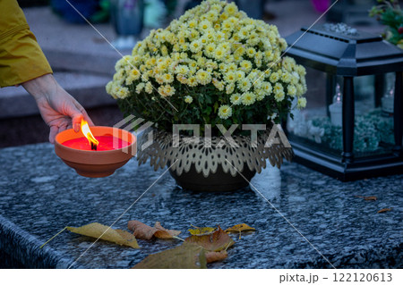 Candle Lighting Ceremony at a Grave Adorned with Marigolds During the Serene Evening 122120613