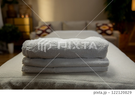 A Cozy Spa Setting Complete with Fresh Towels for Ultimate Relaxation and Comforting Atmosphere 122120829