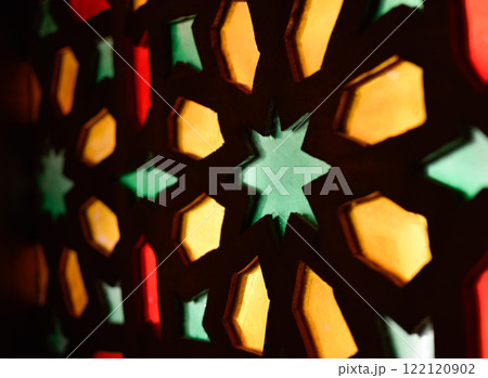 Window with Arabic colored lattice, soft curtain dropped on side and dim light Window with Arabic colored lattice, soft curtain dropped on side and dim light 122120902
