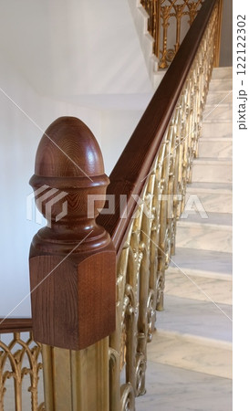 A beautifully crafted, elegant wooden banister that features a striking golden railing design A beautifully crafted, elegant wooden banister that features a striking golden railing design 122122302