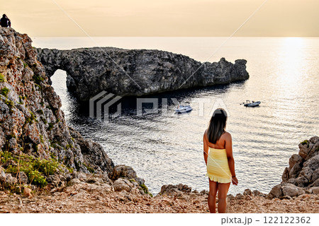 Girl in yellow dress, watching a sunset at Pont den Gil in Ciutadella, Menorca, Balearic Islands. Girl in yellow dress, watching a sunset at Pont den Gil in Ciutadella, Menorca, Balearic Islands. 122122362