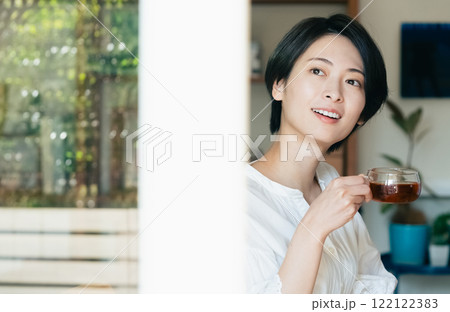 室内から外を見る笑顔の女性 室内から外を見る笑顔の女性 122122383