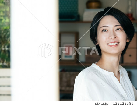 室内から外を見る笑顔の女性 室内から外を見る笑顔の女性 122122389
