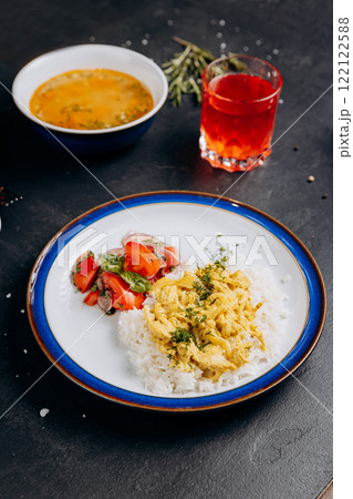 Tasty homemade lunch with soup, rice, curry chicken, fresh salad, and a refreshing red drink Tasty homemade lunch with soup, rice, curry chicken, fresh salad, and a refreshing red drink 122122588