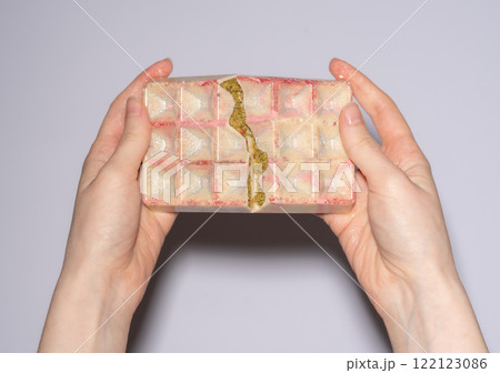 Famous white Dubai chocolate with pistachio, dried raspberry, tahini and kataifi dough filling, chocolate broken in woman's hands. Confectionery and handmade sweets, chocolatier 122123086