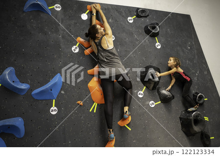 Courageous girl climbing artificial rock wall with Courageous girl climbing artificial rock wall with 122123334