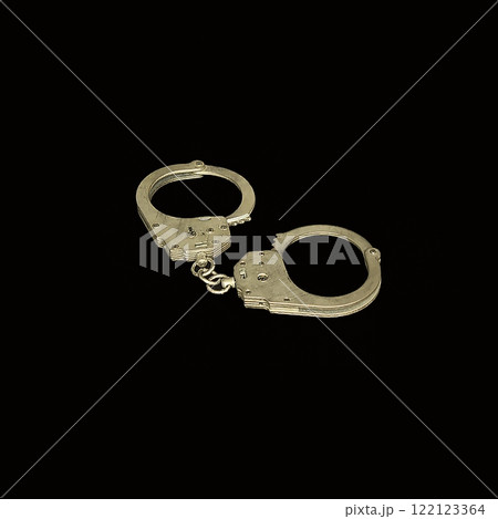 Handcuffs serve as a powerful symbol of law enforcement and the justice system as a whole Handcuffs serve as a powerful symbol of law enforcement and the justice system as a whole 122123364