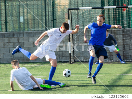 Youthful football players challenging for ball Youthful football players challenging for ball 122125602