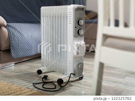 Heating surface of oil heater is on foreground and home space is on background 122125762