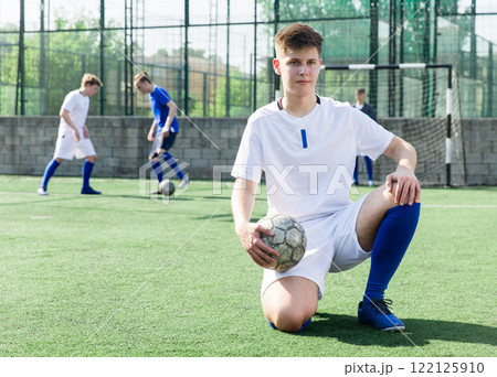 Youth football player sitting on field 122125910