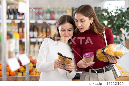 Mother and daughter choose pasta and spaghetti Mother and daughter choose pasta and spaghetti 122125994