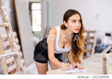 Seductive young woman makes important notes on paper Seductive young woman makes important notes on paper 122126036