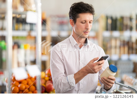 Adult man scanning qr code for mayonnaise Adult man scanning qr code for mayonnaise 122126145