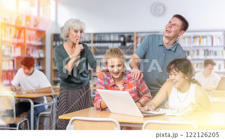 Mature female teacher makes shh sound asks teenage students to be quiet at library Mature female teacher makes shh sound asks teenage students to be quiet at library 122126205