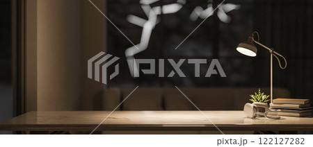 A close-up of a space for displaying product on a tabletop in a dark living room at night. 122127282