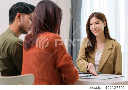 asian financial advisor presenting charts and data on a tablet during couple client meeting.financial planning and decision-making 122127702