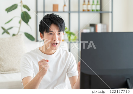 リビングでテレビを見る若い男性 リビングでテレビを見る若い男性 122127719