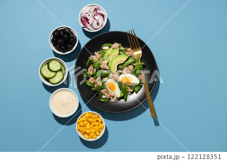 Salad with tuna on a blue background. Salad with tuna on a blue background. 122128351