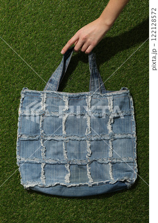 Handmade denim bag in hand on green background, top view Handmade denim bag in hand on green background, top view 122128572