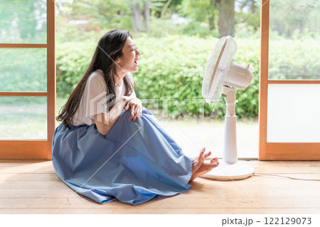 古民家の縁側で扇風機の前でくつろぐ若い女性 122129073