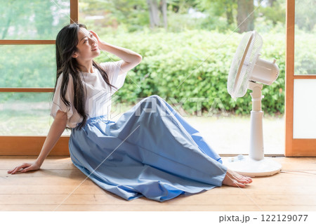 古民家の縁側で扇風機の前でくつろぐ若い女性 122129077