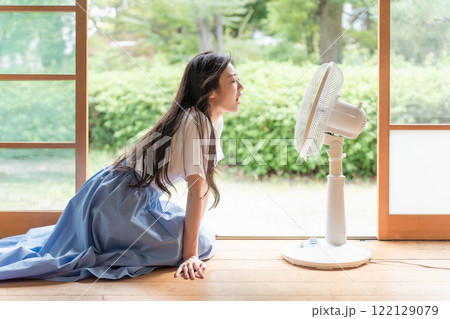 古民家の縁側で扇風機の前でくつろぐ若い女性 122129079