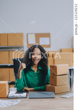 Portrait of Starting small businesses SME owners female entrepreneurs working on receipt box and check online orders to prepare to pack the boxes, sell to customers, SME business ideas online. 122129212