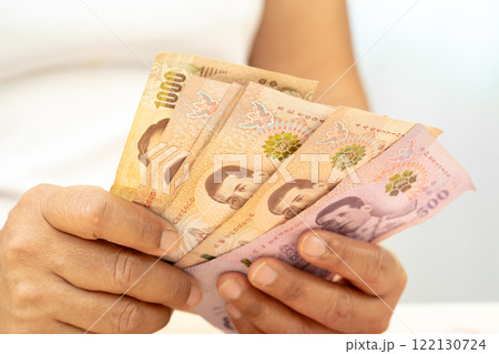 Asian woman holding Thai banknotes money, economy finance exchange trade investment. Asian woman holding Thai banknotes money, economy finance exchange trade investment. 122130724