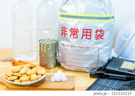 防災用品と一緒に並べられた乾パンと氷砂糖と魚肉ソーセージと缶詰と飲料水 122132215