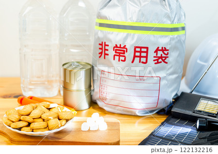 防災用品と一緒に並べられた乾パンと氷砂糖と魚肉ソーセージと缶詰と飲料水 122132216