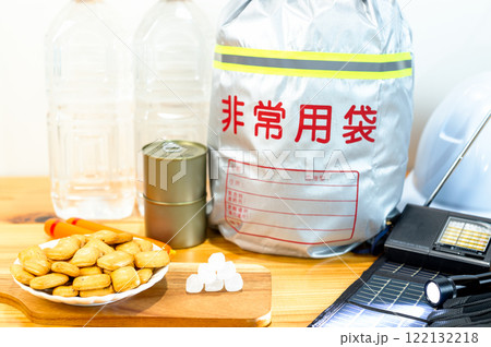 防災用品と一緒に並べられた乾パンと氷砂糖と魚肉ソーセージと缶詰と飲料水 122132218