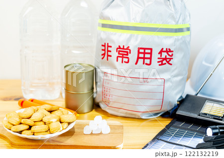 防災用品と一緒に並べられた乾パンと氷砂糖と魚肉ソーセージと缶詰と飲料水 122132219